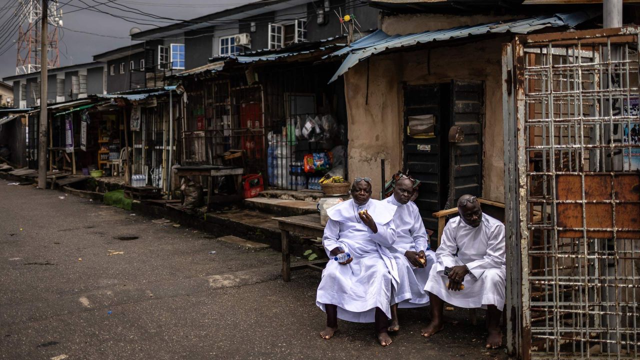 Los fieles descansan fuera de la iglesia durante un servicio religioso en la sede internacional de la Iglesia Celestial de Cristo en el barrio de Ketu, Lagos. | Foto:OLYMPIA DE MAISMONT / AFP