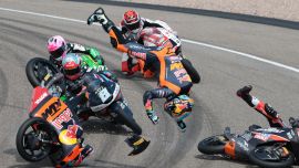 El piloto argentino Valentín Perrone (C, volando por los aires) y el piloto español Marcos Uriarte (D, cayendo en la pista), del equipo Red Bull KTM Tech3, sufren un accidente durante la carrera de Moto3 en el circuito de Sachsenring, en Hohenstein-Ernstthal, cerca de Chemnitz, al este de Alemania, antes del Gran Premio de Alemania de MotoGP.