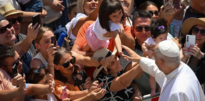 El papa León XIV saluda a la multitud tras el rezo del Ángelus desde la entrada del Palacio Apostólico en la Piazza della Libertà (Plaza de la Libertad) en la residencia papal de verano en Castel Gandolfo.