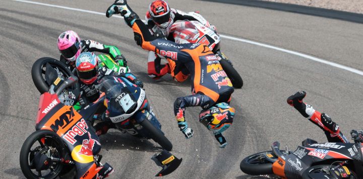 El piloto argentino Valentín Perrone (C, volando por los aires) y el piloto español Marcos Uriarte (D, cayendo en la pista), del equipo Red Bull KTM Tech3, sufren un accidente durante la carrera de Moto3 en el circuito de Sachsenring, en Hohenstein-Ernstthal, cerca de Chemnitz, al este de Alemania, antes del Gran Premio de Alemania de MotoGP.