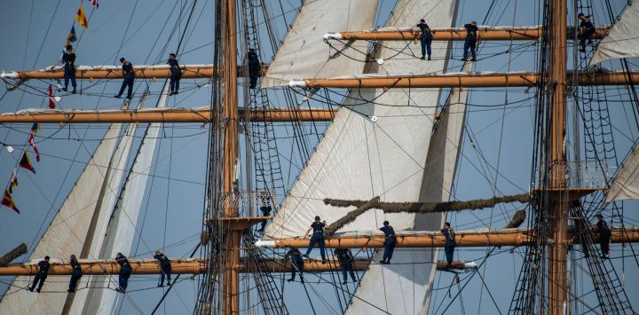 La tripulación del USCGC Eagle trepa por el aparejo durante el desfile náutico Sail Boston Parade of Sail en el puerto de Boston, Massachusetts.