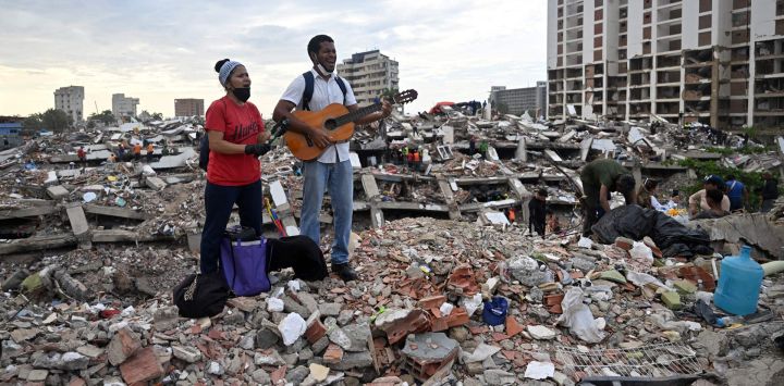 Residentes cantan himnos cristianos entre los escombros del edificio de Obras del Poder Popular (OPP) en Caraballeda, estado de La Guaira, Venezuela, tras los dos terremotos que azotaron la región. Los dos sismos que sacudieron Venezuela el 24 de junio habían dejado casi 4.500 muertos, mientras que gran parte de la población afectada seguía viviendo en campamentos, según cifras oficiales.