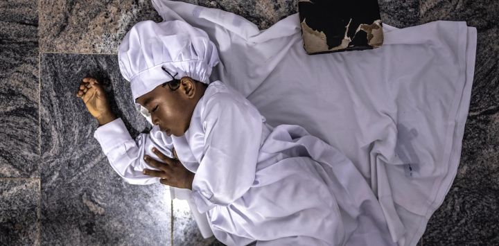 Un niño duerme junto a una Biblia durante un servicio religioso en la sede internacional de la Iglesia Celestial de Cristo en el barrio de Ketu, Lagos.
