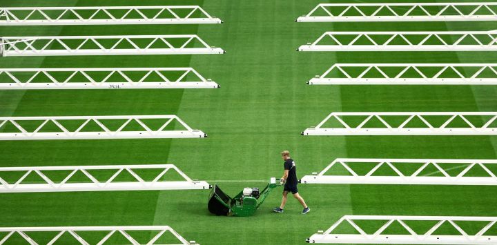 Un trabajador corta el césped en el estadio de Dallas en Arlington antes del partido de semifinales del Mundial de Fútbol de 2026 entre Francia y España.