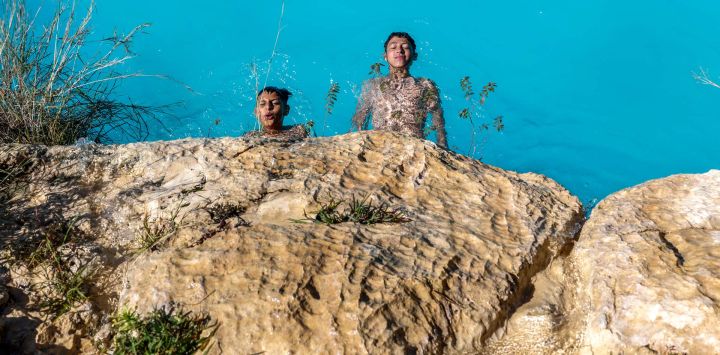 Niños palestinos se refrescan en una piscina conocida como la "Piscina de la Cueva" durante una ola de calor en la aldea de Bilin, al oeste de Ramallah, en la Cisjordania ocupada por Israel.