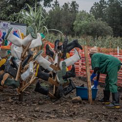 Un trabajador de higiene limpia las botas de los trabajadores sanitarios en el Centro de Tratamiento del Ébola (CTE) de Rwampara, en Bunia, Ituri, al este de la República Democrática del Congo. Los trabajadores sanitarios en el epicentro del brote de ébola en la República Democrática del Congo amenazan con ir a la huelga y declararon a la AFP que no habían recibido su salario desde que se detectó el virus a mediados de mayo. Esta enfermedad altamente infecciosa ha causado la muerte de más de 700 personas entre los casi 2000 casos confirmados en la República Democrática del Congo desde que se declaró el brote el 15 de mayo, según el último balance oficial. | Foto:Benediction Murhabazi / AFP