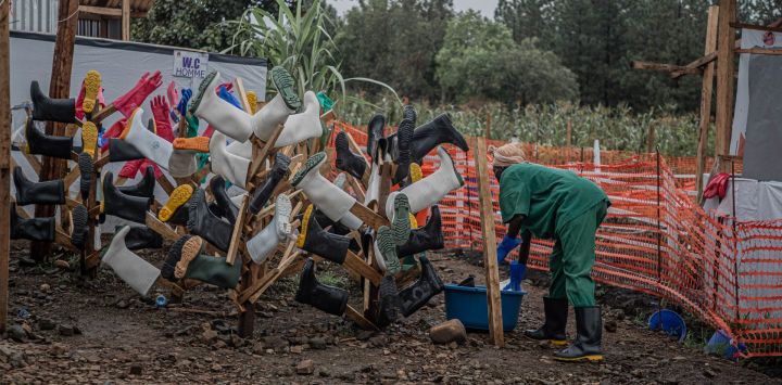 Un trabajador de higiene limpia las botas de los trabajadores sanitarios en el Centro de Tratamiento del Ébola (CTE) de Rwampara, en Bunia, Ituri, al este de la República Democrática del Congo. Los trabajadores sanitarios en el epicentro del brote de ébola en la República Democrática del Congo amenazan con ir a la huelga y declararon a la AFP que no habían recibido su salario desde que se detectó el virus a mediados de mayo. Esta enfermedad altamente infecciosa ha causado la muerte de más de 700 personas entre los casi 2000 casos confirmados en la República Democrática del Congo desde que se declaró el brote el 15 de mayo, según el último balance oficial.