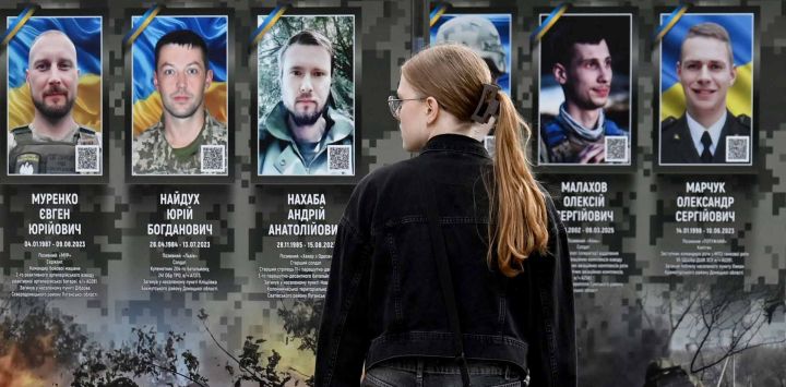 Una niña observa retratos en el Paseo de los Héroes Caídos en un distrito de Kiev, en medio de la invasión rusa de Ucrania.