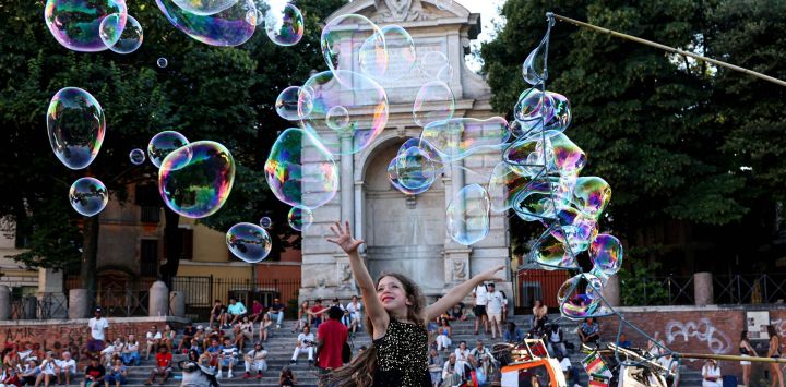 Imagen de una niña jugando con burbujas en una plaza a lo largo del río Tíber, en Roma, Italia. La XXIV edición del evento "A lo largo del Tíber, Roma" se celebra aquí, a orillas del Tíber, y se extenderá hasta finales de agosto.