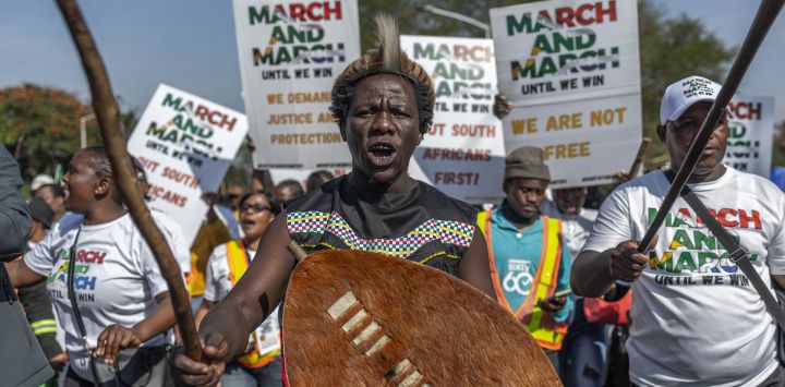 Manifestantes del Movimiento March and March portan pancartas y corean consignas durante una protesta en Pinetown, al sur de Durban. El grupo exige medidas más contundentes contra la inmigración ilegal y la deportación de extranjeros indocumentados. Los organizadores también instaron al gobierno y a los funcionarios del Ministerio del Interior a agilizar la tramitación de documentos de identidad para aproximadamente cuatro millones de sudafricanos que, según afirman, siguen sin tener un documento de identidad oficial. La protesta se produce en medio de un debate nacional más amplio sobre la seguridad fronteriza, la aplicación de la ley y las políticas de inmigración de Sudáfrica.