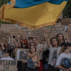 Manifestantes ondean una bandera ucraniana, portan pancartas y corean consignas durante una protesta contra la decisión del presidente de Ucrania de destituir al ministro de Defensa, Mykhailo Fedorov, y exigen la destitución del jefe del ejército ucraniano, Oleksandr Syrskyi. La protesta tuvo lugar en Kiev en medio de la invasión rusa de Ucrania. Varias ciudades ucranianas protagonizaron grandes protestas contra la destitución del popular ministro de Defensa, Fedorov, quien había sido nombrado seis meses antes para digitalizar y modernizar un ejército exhausto tras cuatro años de lucha contra la invasión rusa. | Foto:ROMAN PILIPEY / AFP