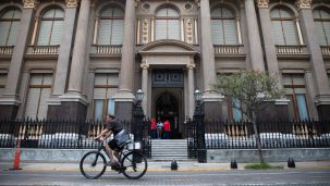 Un hombre circula en una bicicleta frente a la sede del Banco Central de la República Argentina (BCRA)