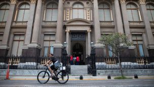 Un hombre circula en una bicicleta frente a la sede del Banco Central de la República Argentina (BCRA)