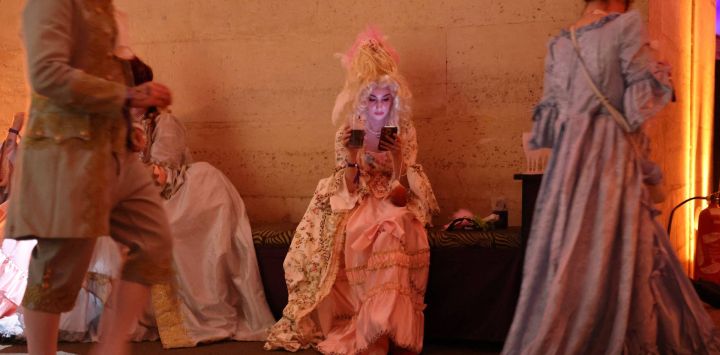 Asistentes ataviados con trajes de época participan en la 14.ª edición del evento de baile de máscaras The Grand Masked Ball, celebrado en la Orangerie del Palacio de Versalles, al suroeste de París.