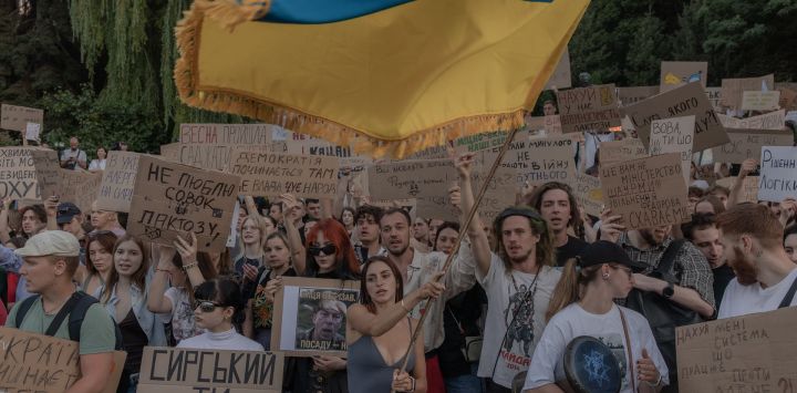 Manifestantes ondean una bandera ucraniana, portan pancartas y corean consignas durante una protesta contra la decisión del presidente de Ucrania de destituir al ministro de Defensa, Mykhailo Fedorov, y exigen la destitución del jefe del ejército ucraniano, Oleksandr Syrskyi. La protesta tuvo lugar en Kiev en medio de la invasión rusa de Ucrania. Varias ciudades ucranianas protagonizaron grandes protestas contra la destitución del popular ministro de Defensa, Fedorov, quien había sido nombrado seis meses antes para digitalizar y modernizar un ejército exhausto tras cuatro años de lucha contra la invasión rusa.