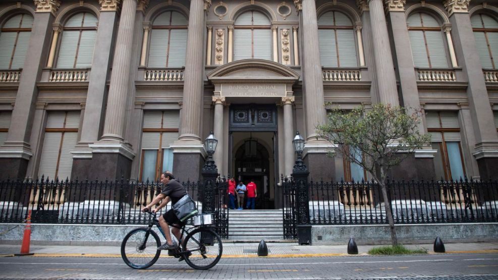 Un hombre circula en una bicicleta frente a la sede del Banco Central de la República Argentina (BCRA)