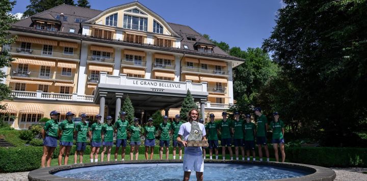 El griego Stefanos Tsitsipas posa con el trofeo en una fuente tras su victoria sobre el belga Raphael Collignon en la final individual masculina del Abierto de Suiza de tenis en Gstaad.