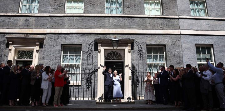 El nuevo primer ministro británico, Andy Burnham, y su esposa, Marie-France van Heel, posan en las escaleras del número 10 de Downing Street, en el centro de Londres, tras ser invitados por el rey a formar el próximo gobierno.