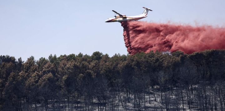 Un avión Dash 8-Q400MR lanza retardante de fuego para frenar la propagación de un incendio forestal en Taradeau, en el departamento de Var, en la región de Provenza-Alpes-Costa Azul, al sureste de Francia.