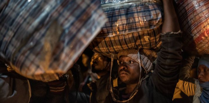 Un migrante malauí carga sus pertenencias mientras hace fila para abordar un autobús frente al Consulado de Malaui en Johannesburgo, antes de su repatriación a Malaui. Varios miles de extranjeros más exigieron abandonar Sudáfrica, tras una campaña que ya ha visto regresar a sus hogares a cerca de 35.000 personas. El éxodo comenzó semanas atrás, cuando grupos marginales exigieron que todos los inmigrantes indocumentados se marcharan antes del 30 de junio, en una campaña que derivó en violentas protestas y enfrentamientos.