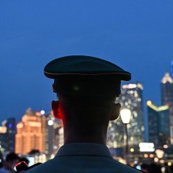 Un miembro de la policía paramilitar china monta guardia en el Bund de Shanghái. | Foto:Hector Retamal / AFP