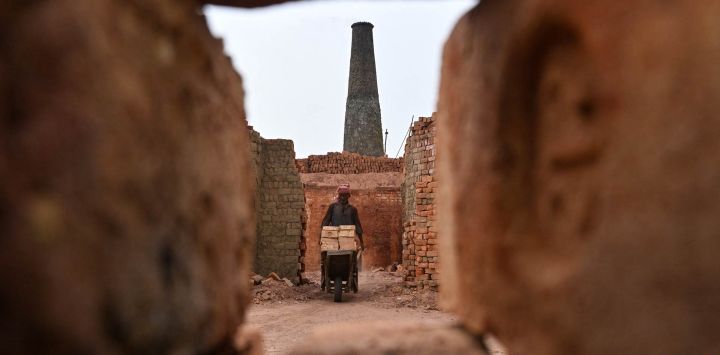 Un trabajador empuja una carretilla en un horno de ladrillos en Sheikhupura, en la provincia de Punjab, Pakistán.