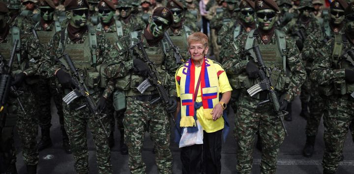 Una mujer posa con soldados antes de un desfile militar en conmemoración del Día de la Independencia de Colombia en Bogotá.