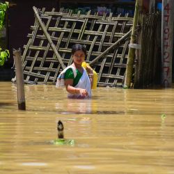 Una aldeana camina a través de las aguas de la inundación tras las fuertes lluvias, en el distrito de Jorhat del estado de Assam, en el noreste de India. | Foto:Xinhua/Str