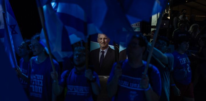 Simpatizantes ondean banderas junto a un retrato del líder del partido HaDemokratim ("Los Demócratas") y exmiembro del Knesset, Yair Golan, durante el acto de lanzamiento de la campaña del partido tras sus primarias, de cara a las elecciones generales del país en Tel Aviv. Israel celebrará elecciones nacionales el 27 de octubre, la última fecha permitida por la ley, según anunció su parlamento. La votación se considera un referéndum sobre el liderazgo del primer ministro desde que estalló la guerra de Gaza.