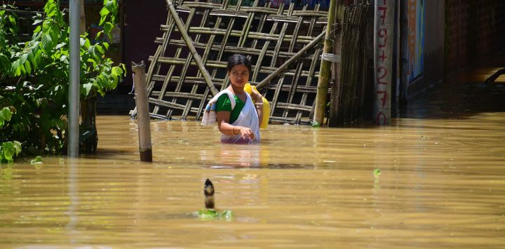 Una aldeana camina a través de las aguas de la inundación tras las fuertes lluvias, en el distrito de Jorhat del estado de Assam, en el noreste de India.