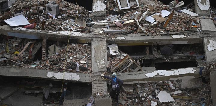 Una persona permanece de pie entre los escombros de un edificio de varios pisos derrumbado en Caraballeda, Venezuela, tras los terremotos del 24 de junio.