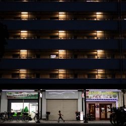 Un niño corre frente a un edificio de apartamentos en un complejo residencial en el distrito de Koto, Tokio. | Foto:Philip Fong / AFP