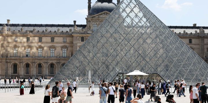 Turistas son vistos cerca del Museo del Louvre, en París, Francia.