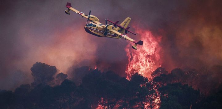 Un avión Canadair CL-415 de la Seguridad Civil francesa sobrevuela las llamas que arrasan un bosque en los alrededores de Cotignac, en el sureste de Francia, durante un incendio forestal.