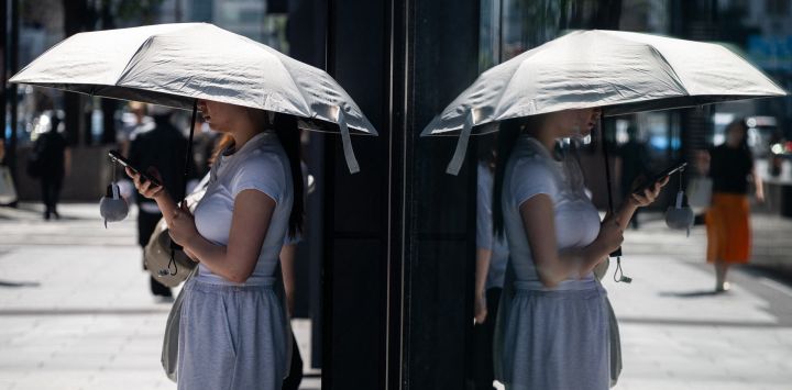 Una mujer se protege del sol con un paraguas en una calurosa mañana en Tokio.