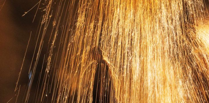 Un tezutsu-shu, un artista tradicional de fuegos artificiales sostenidos con el brazo, es rociado con chispas de tezutsu hanabi, tubos de bambú hechos a mano rellenos de pólvora que estallan en una imponente columna de chispas y llamas, durante el Festival de Fuegos Artificiales de Brazo de Tatebayashi en Tatebayashi, prefectura de Gunma, Japón.
