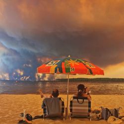 Bañistas contemplan el paisaje desde la playa de Moutchic, en Lacanau, al suroeste de Francia, mientras columnas de humo se elevan hacia el cielo a causa del incendio forestal de la Gironda. El fuego, que azota la zona norte de la cuenca de Arcachon, en la Gironda, al suroeste de Francia, ha arrasado más de 3.400 hectáreas, según las últimas cifras publicadas por la prefectura. | Foto:Maximilien Lamy / AFP