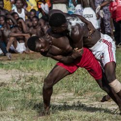 Jóvenes compiten en el ritual de lucha Evala en la localidad de Lama-Feing, en la región de Kara, al norte de Togo. Tras una ceremonia en el bosque de las alturas de Lama-Feing, una aldea del norte de Togo, una treintena de jóvenes con el torso desnudo caminan con paso firme por los senderos, entonando cánticos de guerra: están a punto de participar en los tradicionales combates de lucha iniciáticos, el "Evala", que marcan el paso a la edad adulta. | Foto:Alphonse Adzamavi / AFP