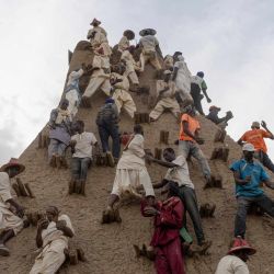 Residentes aplican barro al minarete durante la renovación del revestimiento de la Mezquita de Sankore, como parte de un evento que conmemora su 600 aniversario, en Tombuctú, Malí. Cientos de personas se congregaron en la histórica ciudad de Tombuctú para renovar el revestimiento de la Mezquita de Sankore como parte de las celebraciones de su 600 aniversario. Construida en el siglo XIV, es una de las tres grandes mezquitas de Tombuctú, junto con Djingareyber y Sidi Yahia. Juntas, son ejemplos únicos de arquitectura de tierra y desempeñaron un papel importante en la temprana expansión del islam en África. | Foto:AFP