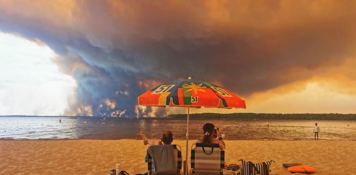 Bañistas contemplan el paisaje desde la playa de Moutchic, en Lacanau, al suroeste de Francia, mientras columnas de humo se elevan hacia el cielo a causa del incendio forestal de la Gironda. El fuego, que azota la zona norte de la cuenca de Arcachon, en la Gironda, al suroeste de Francia, ha arrasado más de 3.400 hectáreas, según las últimas cifras publicadas por la prefectura.
