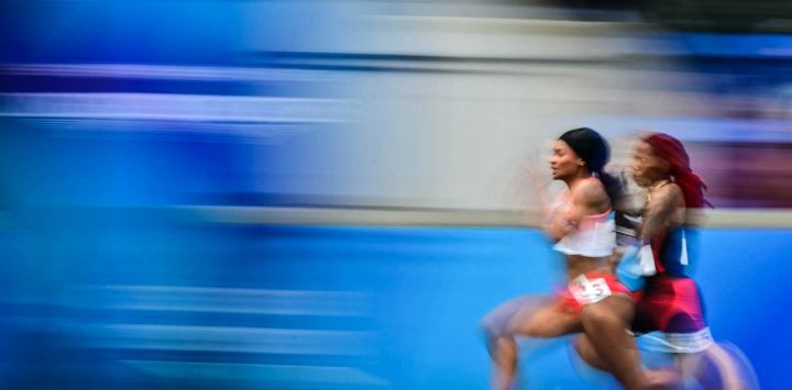 La canadiense Gabrielle Cole (derecha) y la fiyiana Heleina Valetta Young (izquierda) compiten en la quinta serie de los 100 metros femeninos durante la prueba de atletismo celebrada en el estadio Scotstoun de Glasgow, en el cuarto día de los Juegos de la Commonwealth en Glasgow, Escocia.