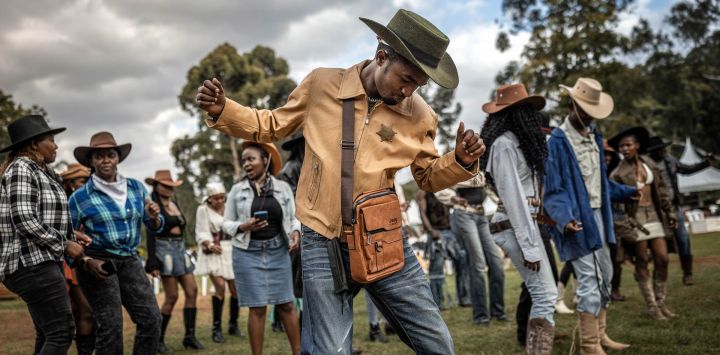 Los asistentes, ataviados con trajes de vaquero, bailan al ritmo de la música country durante las celebraciones del Día Internacional del Vaquero en el hipódromo de Ngong, en Nairobi, Kenia. Celebrado anualmente el Día Internacional del Vaquero conmemora la historia, la cultura y el legado perdurable de los vaqueros y vaqueras de todo el mundo. Si bien tiene sus raíces en las tradiciones de Norteamérica, la cultura vaquera y la música country han ganado cada vez más adeptos en algunas partes de África en los últimos años, especialmente en Kenia, donde la moda del Oeste, el baile en línea, la equitación y los eventos de música country han atraído a una creciente comunidad de aficionados.