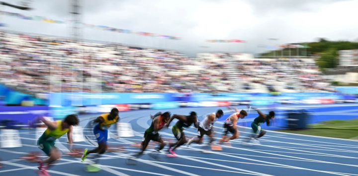 Los atletas compiten en la séptima serie de los 100 metros masculinos durante la prueba de atletismo en el estadio Scotstoun de Glasgow, en el cuarto día de los Juegos de la Commonwealth en Glasgow, Escocia.
