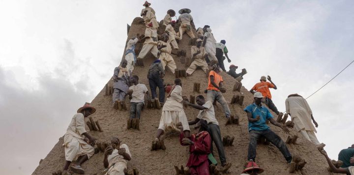 Residentes aplican barro al minarete durante la renovación del revestimiento de la Mezquita de Sankore, como parte de un evento que conmemora su 600 aniversario, en Tombuctú, Malí. Cientos de personas se congregaron en la histórica ciudad de Tombuctú para renovar el revestimiento de la Mezquita de Sankore como parte de las celebraciones de su 600 aniversario. Construida en el siglo XIV, es una de las tres grandes mezquitas de Tombuctú, junto con Djingareyber y Sidi Yahia. Juntas, son ejemplos únicos de arquitectura de tierra y desempeñaron un papel importante en la temprana expansión del islam en África.