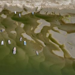 La vista aérea muestra embarcaciones en las aguas poco profundas del río Danubio en Corabia, al sur de Rumania. La prolongada sequía y el calor extremo en toda Europa han provocado que el nivel del agua del Danubio alcance mínimos históricos para la época del año, registrando su caudal más bajo en los últimos 30 años. | Foto:DANIEL MIHAILESCU / AFP
