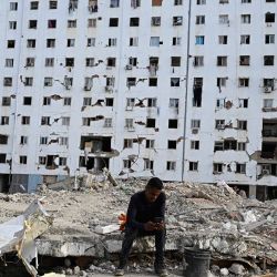 Un hombre descansa entre los escombros de un edificio derrumbado durante una misa en Caraballeda, Venezuela, un mes después del terremoto que azotó la zona. | Foto:Federico Parra / AFP