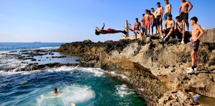 Imagen de personas sumergiéndose en el mar mientras el país experimenta una ola de calor en la isla Zireh frente a la costa de Sidón, Líbano.