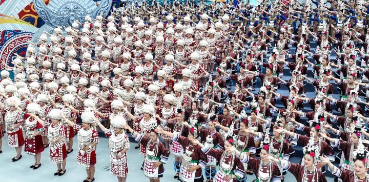 Imagen tomada con un dron de personas de grupos étnicos minoritarios realizando una presentación durante una ceremonia para conmemorar el 70 aniversario de la fundación de la prefectura autónoma de las etnias miao y dong de Qiandongnan, en Kaili, en la provincia de Guizhou, en el suroeste de China.
