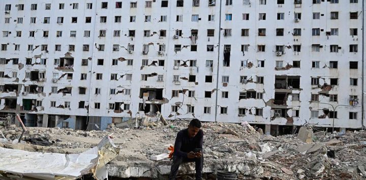 Un hombre descansa entre los escombros de un edificio derrumbado durante una misa en Caraballeda, Venezuela, un mes después del terremoto que azotó la zona.