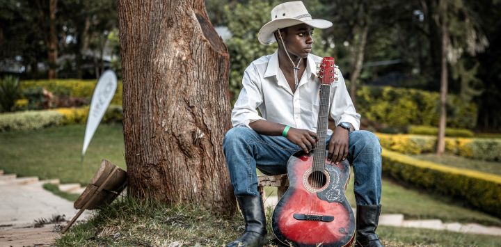 Un músico de country vestido de vaquero sostiene su guitarra mientras espera para actuar durante las celebraciones del Día Internacional del Vaquero en el Hipódromo de Ngong, en Nairobi. El Día Internacional del Vaquero conmemora la historia, la cultura y el legado perdurable de los vaqueros y vaqueras de todo el mundo. Si bien tiene sus raíces en las tradiciones de Norteamérica, la cultura vaquera y la música country han ganado cada vez más adeptos en algunas partes de África en los últimos años, especialmente en Kenia, donde la moda del Oeste, el baile en línea, la equitación y los eventos de música country han atraído a una creciente comunidad de aficionados.
